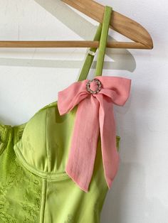 Vintage Victoria’s Secret Lime Green Bustier. A cutesy femme bustier with lace panel going down the front of the bodice and along the tops of the cups. Has boning and underwire. Delicate flower pattern stitched into the silk. Pink bow with circular rhinestone buckle adorning the left strap. In excellent condition. Body is a poly blend, bow is 100% silk. Hand wash cold. Marked size 36B. Approximate Measurements: Cup width: 6" Cup height without lace: 4" Underarm to underarm: 16" Length: 18" Sleeveless Lace Corset With Removable Bra Pads, Sleeveless Lace Bodice Summer Corset, Summer Lace Corset With Lined Bodice, Summer Boned Bodice, Sweetheart Neckline Bodice For Summer, Summer Corset With Lace And Fitted Bodice, Summer Corset With Lace Bodice, Summer Lace Bodice Fitted Corset, Fitted Lace Bodice Corset For Summer