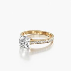 a yellow gold engagement ring with an oval cut diamond on the side and pave set shoulders