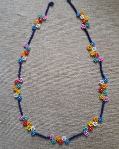 a colorful beaded necklace is displayed on the floor