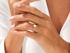 a woman's hand with a diamond ring on it