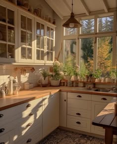 a kitchen filled with lots of white cupboards and counter top next to a window