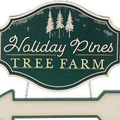 a holiday pines tree farm sign hanging from the side of a building