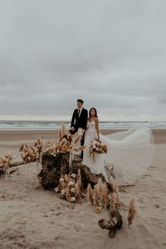 a newly married couple standing on the beach