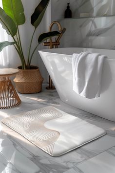 a white bath tub sitting on top of a bathroom counter next to a potted plant