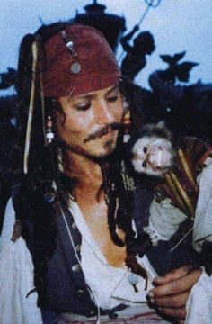 a man in pirate costume holding an animal