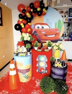 cars birthday party decoration with balloons and decorations on red carpeted flooring in front of wall