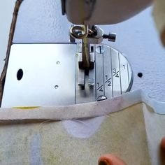 someone is using a sewing machine to sew something on the side of a piece of fabric