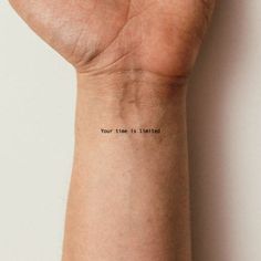 a person's wrist with the words your time is limited written on it,