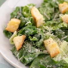 a salad with croutons and parmesan cheese