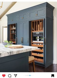 a kitchen with blue cabinets and marble counter tops