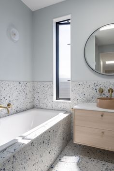 a bathroom with blue speckles on the walls and white bathtub next to a window