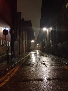 an empty city street at night in the rain