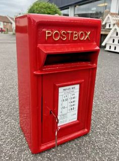 a red post box sitting on the ground