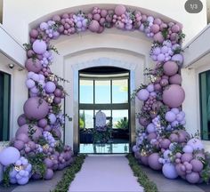 an entrance decorated with purple balloons and greenery