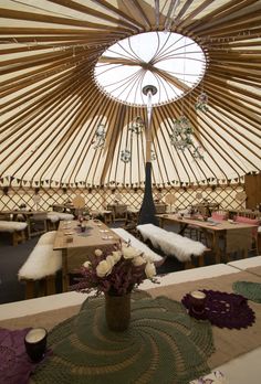 the inside of a yurt with tables and chairs