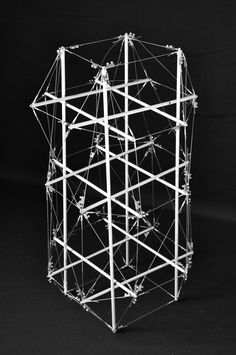 a sculpture made out of multiple wires on a black background, with the top part of it's structure exposed