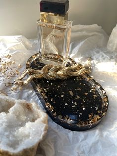 A glam resin trinket tray with gold flakes in clear resin and a black background. A luxury perfume and a gold knit bracelet are okaced in the jewelry treat Perfume Tray On Dresser, Aesthetic Perfume Tray, Clear Perfume Tray, Nightstand Tray, Chic Perfume, Perfume Mirror Tray, Bedside Tray, Jewelry Content