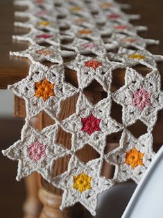 a crocheted table runner on top of a wooden chair