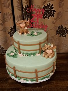 a three tiered cake with two teddy bears on top and happy birthday written on the side