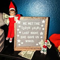 an elf is holding a sign that says we met the 100 - dollar fairy last night, she gave us wings