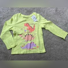 Dinosaur Yellow Long Sleeve, Never Been Worn Casual Green Dinosaur Print Tops, Long Sleeve Cotton Tops With Dinosaur Print, Long Sleeve Cotton Top With Dinosaur Print, Cotton Long Sleeve Tops With Dinosaur Print, Casual Green Tops With Dinosaur Print, Long Sleeve Tops With Dinosaur Print For Playtime, Yellow Long Sleeve Top With Character Print, Long Sleeve Character Print Playtime T-shirt, Cotton Tops With Dinosaur Print For Spring