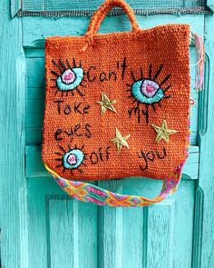 an orange purse hanging on the side of a blue door with words written on it