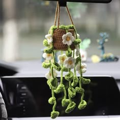 a crocheted flower hanging from the dashboard of a car