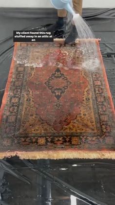 a rug is being washed with water from a sprayer on top of the rug