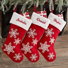 three red christmas stockings with white snowflakes on them