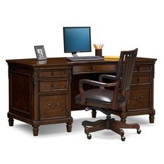 an office desk with a computer on top of it and a chair next to it