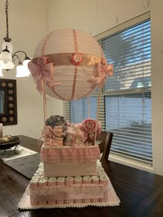 a table topped with a cake shaped like a hot air balloon and lots of decorations