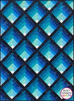 a blue and black quilt with squares in the center, on top of it is an image