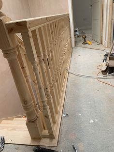 an unfinished staircase being worked on by a person with a power drill and screwdriver