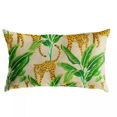 a pillow with leopards and palm leaves on it