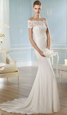 a woman in a white wedding dress posing for the camera with her hand on her hip