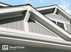 the roof of a house with gray siding and white trim