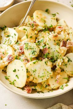 a white bowl filled with potatoes covered in parsley