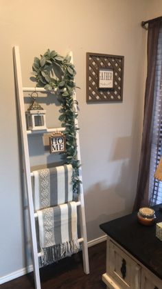 a ladder leaning up against a wall in a living room next to a dresser and window