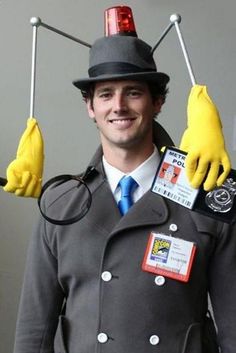 a man dressed as a doctor who has yellow gloves on his head and is wearing a hat