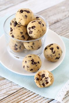 chocolate chip cookies in a glass bowl on a white plate next to a blue napkin