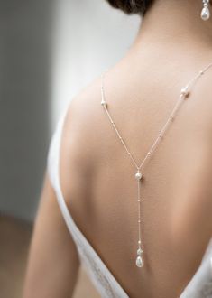 the back of a woman's neck with pearls on it