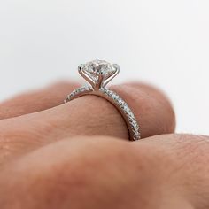 a close up of a person's hand holding a diamond ring