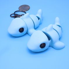 four white dog shaped key chains with a penny sitting on top of them next to each other