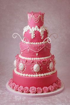 a three tiered cake with pink frosting and flowers