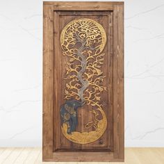 an elephant and tree carved into a wooden frame