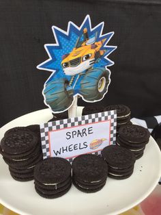 there is a cake with cookies on it and an image of a monster truck in the background