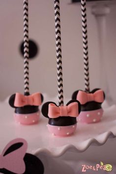 minnie mouse cupcakes with black and white striped straws in the shape of ears