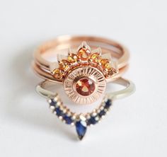 three rings with different colored stones on top of each other and one has a crown