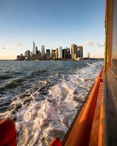 the city skyline as seen from a boat on the water with waves in front of it