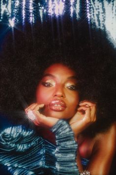 a woman with an afro is posing for the camera